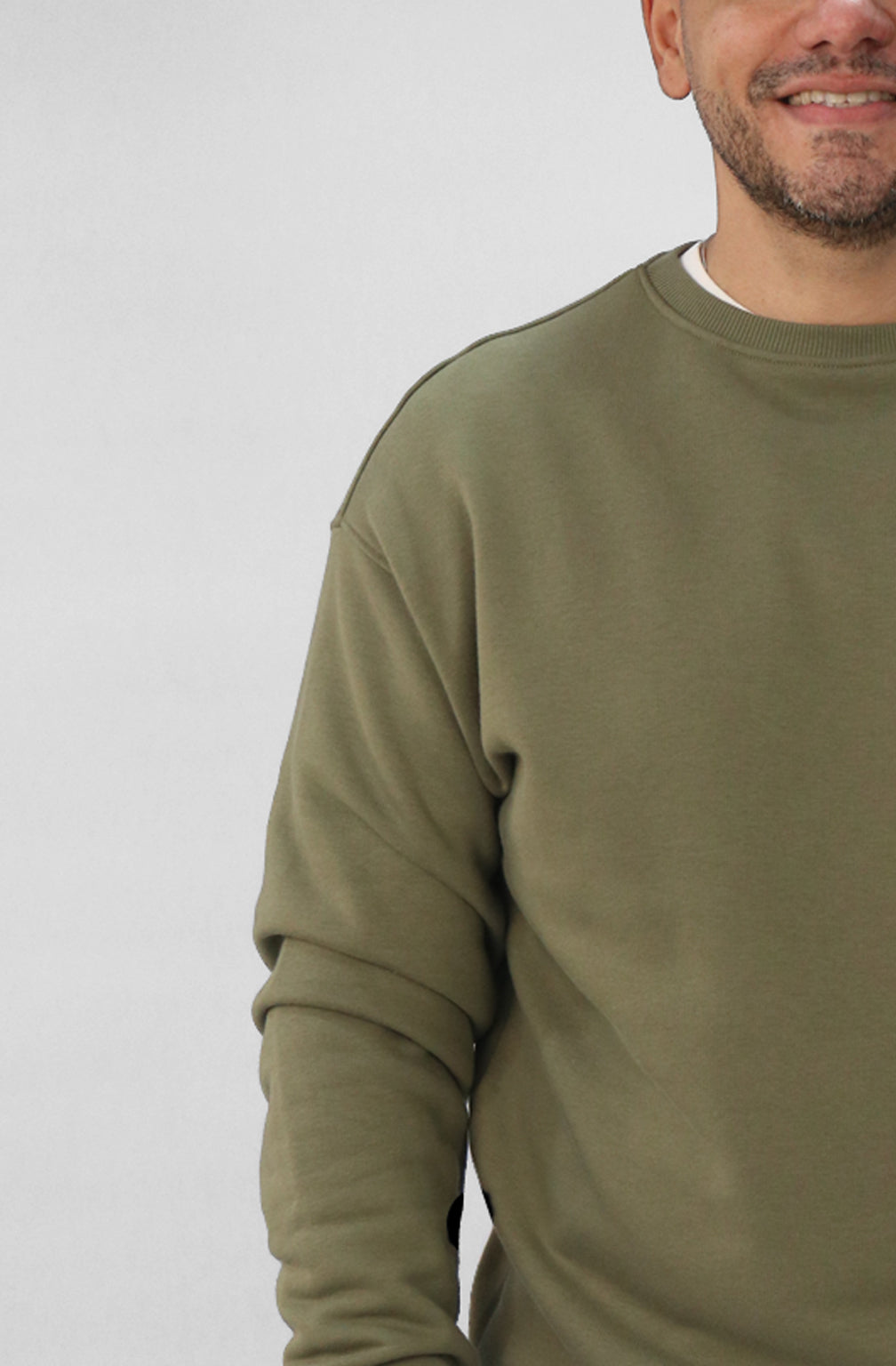 Person wearing a green sweatshirt against a plain background